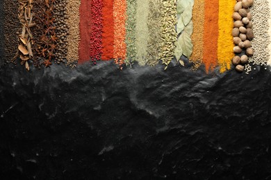 Photo of Many different spices on black table, flat lay. Space for text