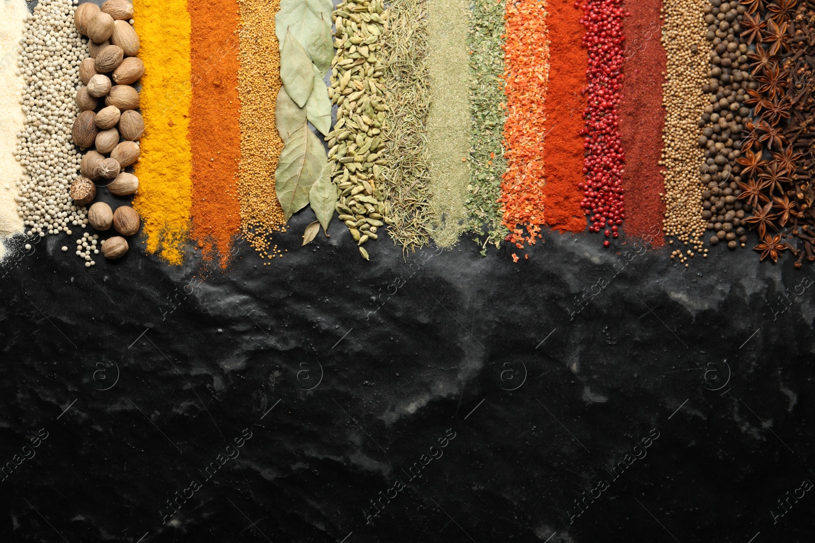 Photo of Many different spices on black table, flat lay. Space for text