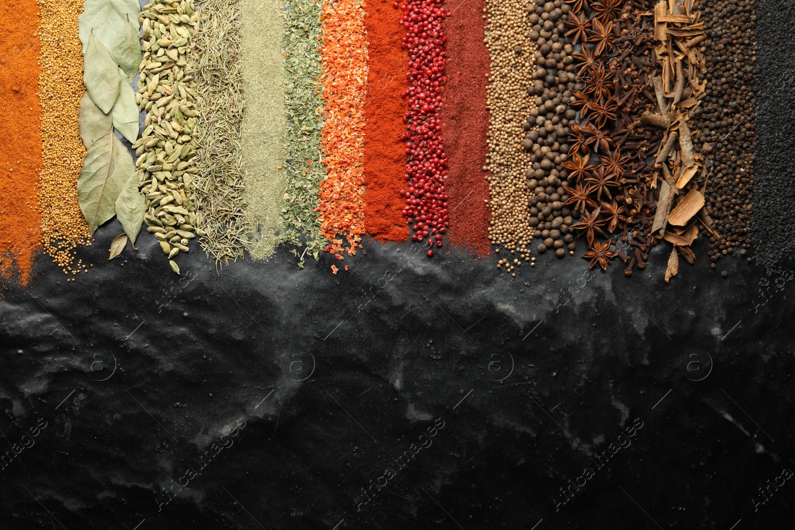 Many different spices on black table, flat lay. Space for text Photo of Many different spices on black table, flat lay. Space for text