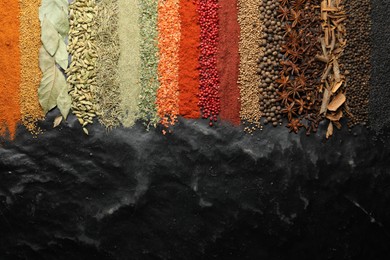 Photo of Many different spices on black table, flat lay. Space for text