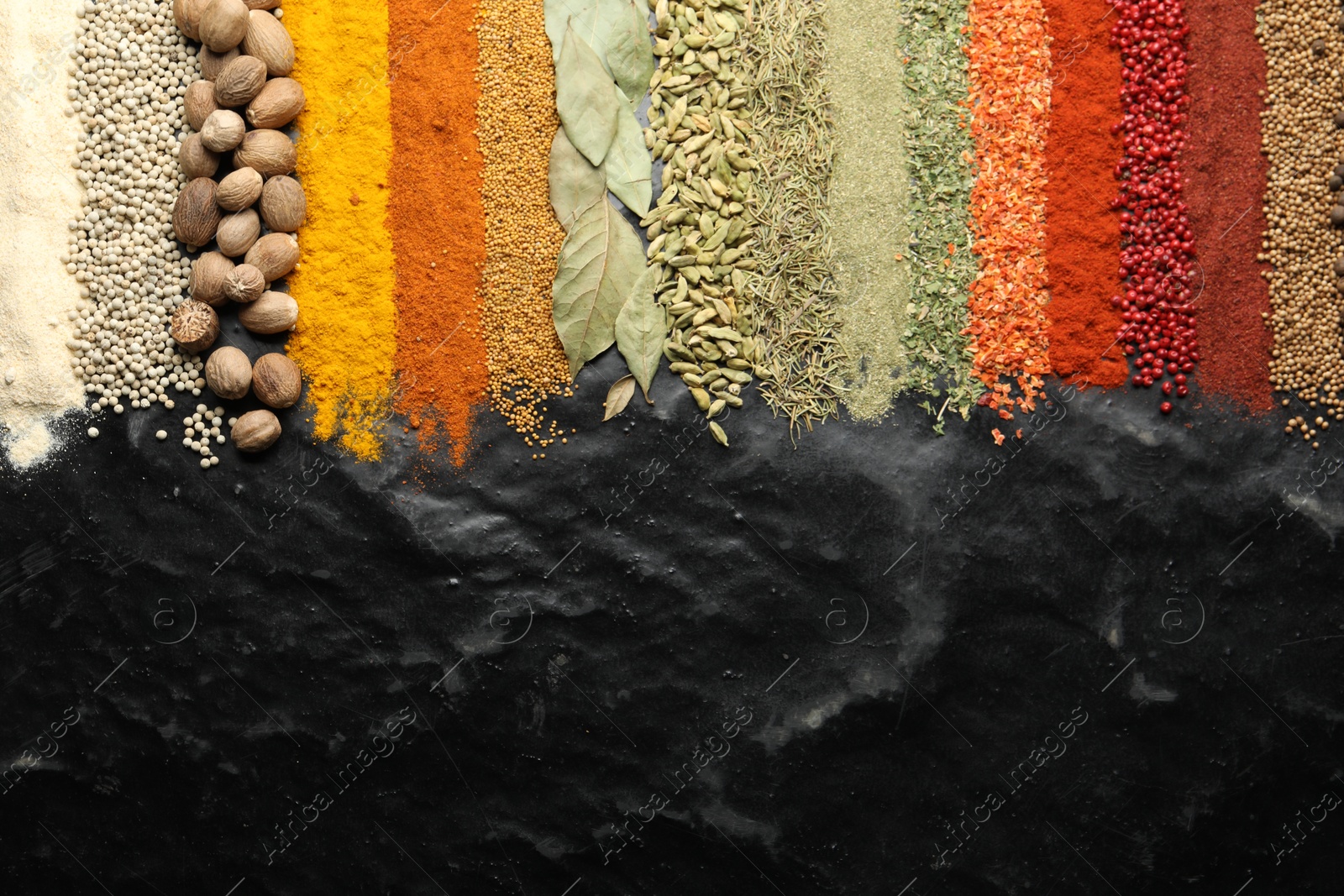 Photo of Many different spices on black table, flat lay. Space for text