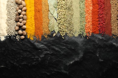 Photo of Many different spices on black table, flat lay. Space for text