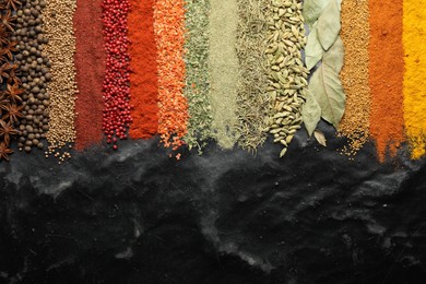 Photo of Many different spices on black table, flat lay. Space for text