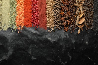 Photo of Many different spices on black table, flat lay. Space for text