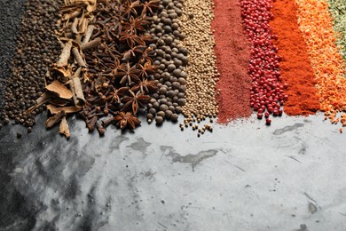 Photo of Many different spices on black table, closeup. Space for text