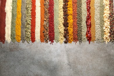 Photo of Many different spices on grey table, flat lay. Space for text