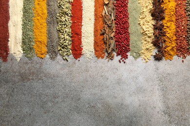 Photo of Many different spices on grey table, flat lay. Space for text