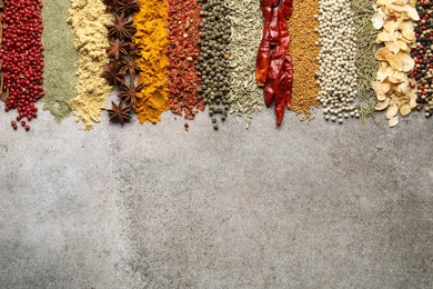 Photo of Many different spices on grey table, flat lay. Space for text