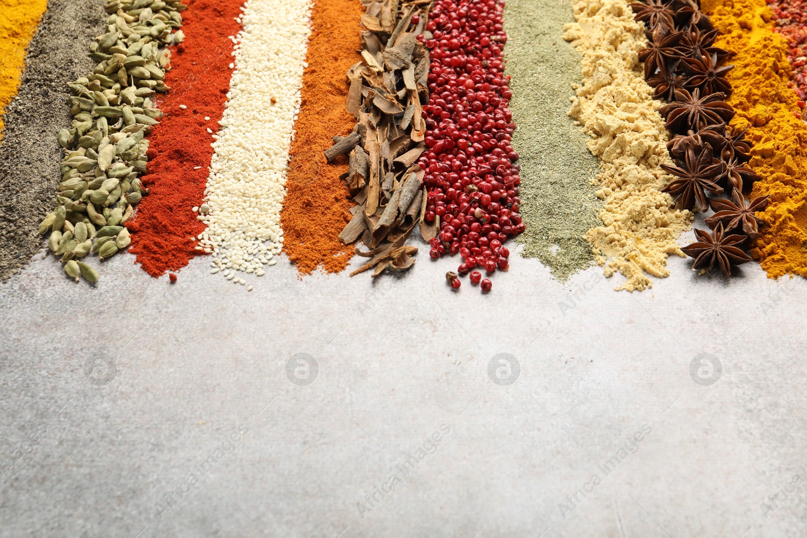 Many different spices on light grey table, closeup. Space for text Photo of Many different spices on light grey table, closeup. Space for text