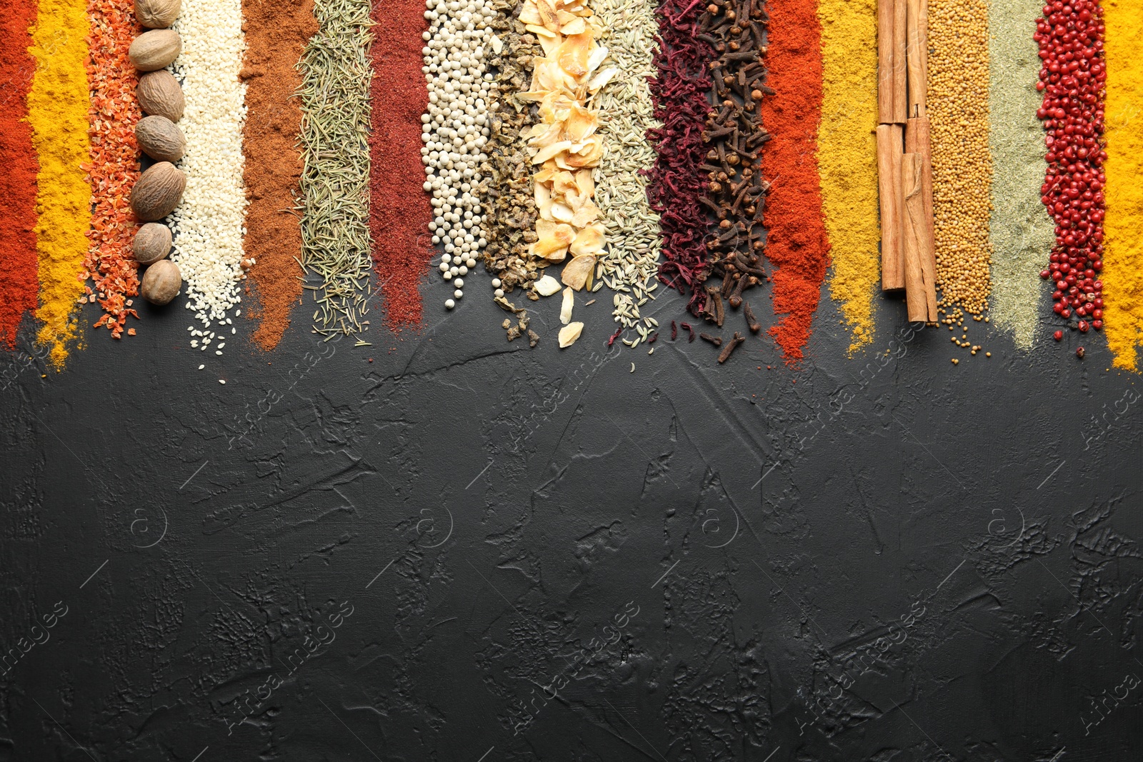 Many different spices on black table, flat lay. Space for text Photo of Many different spices on black table, flat lay. Space for text