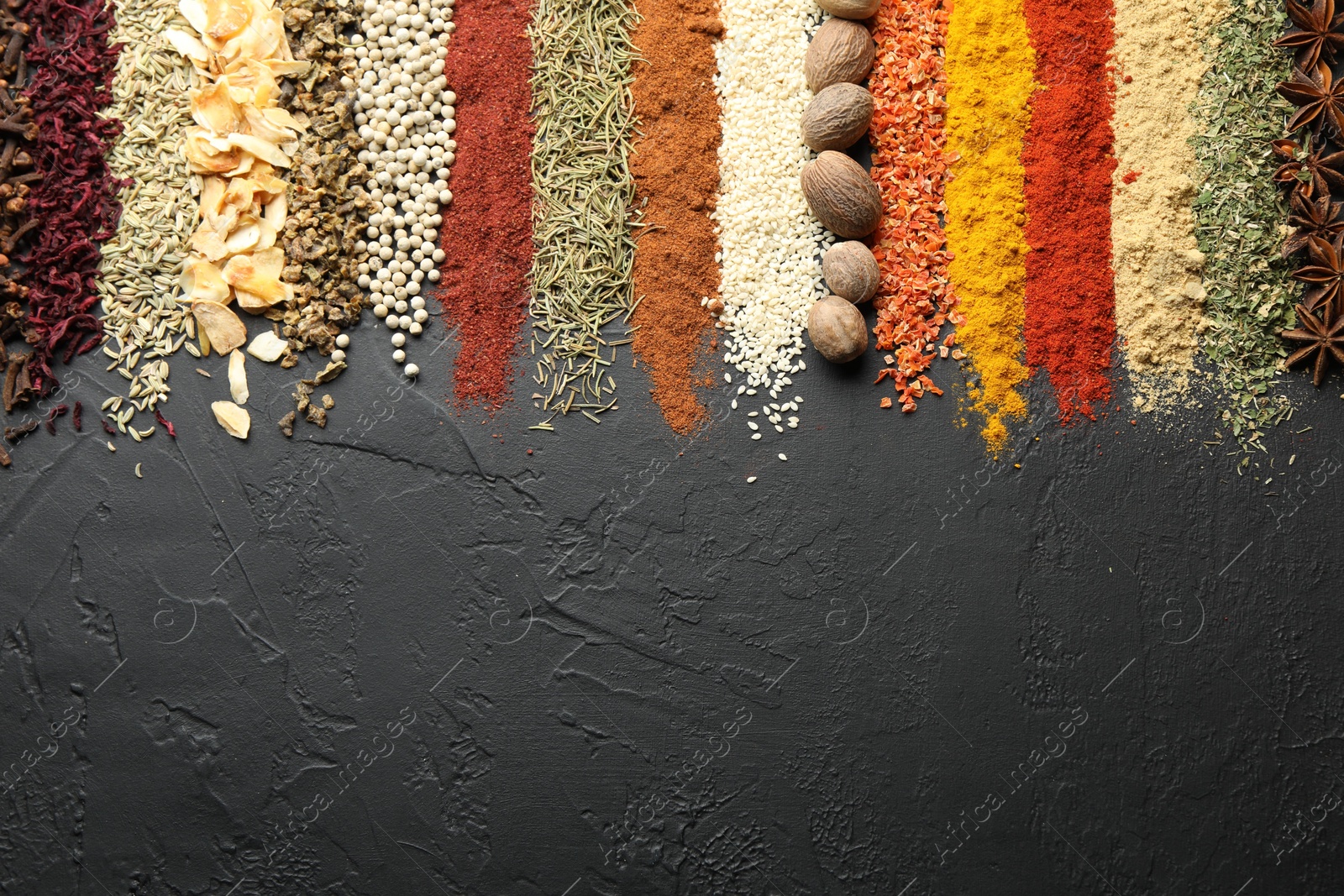 Many different spices on black table, flat lay. Space for text Photo of Many different spices on black table, flat lay. Space for text