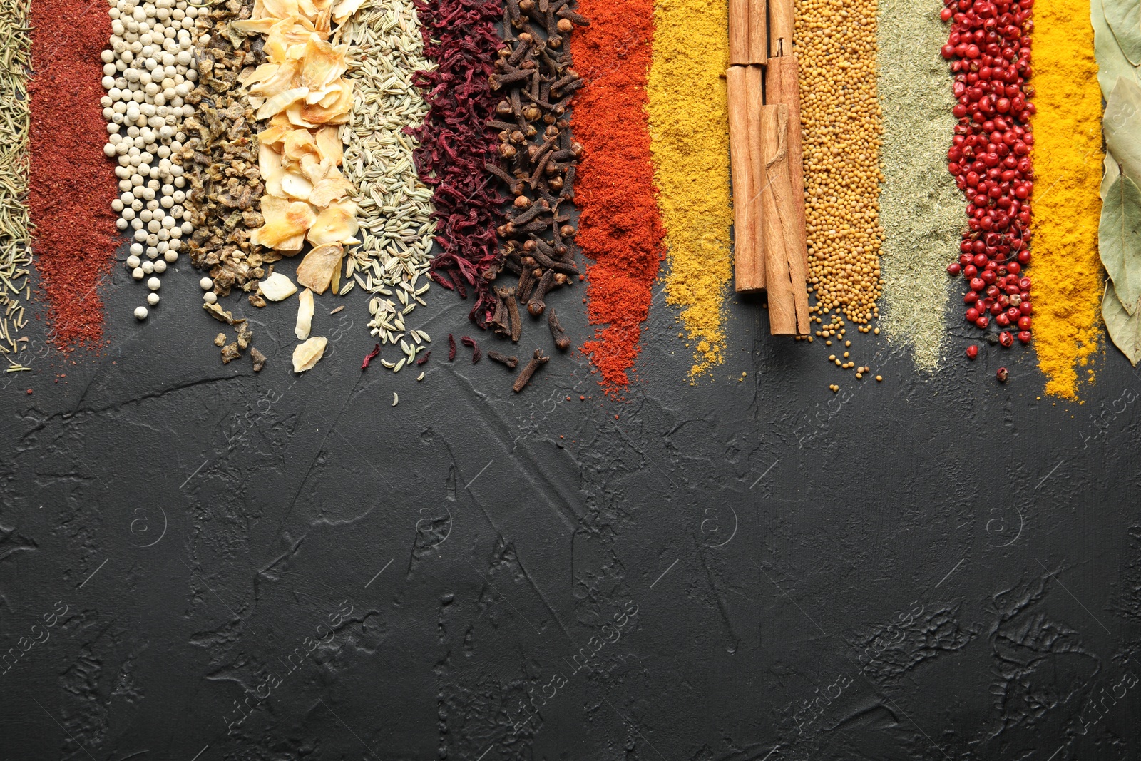 Many different spices on black table, flat lay. Space for text Photo of Many different spices on black table, flat lay. Space for text