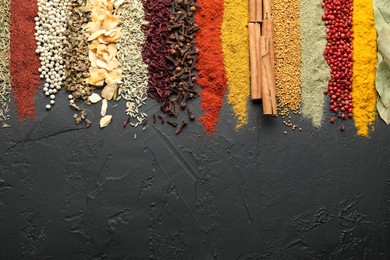 Photo of Many different spices on black table, flat lay. Space for text