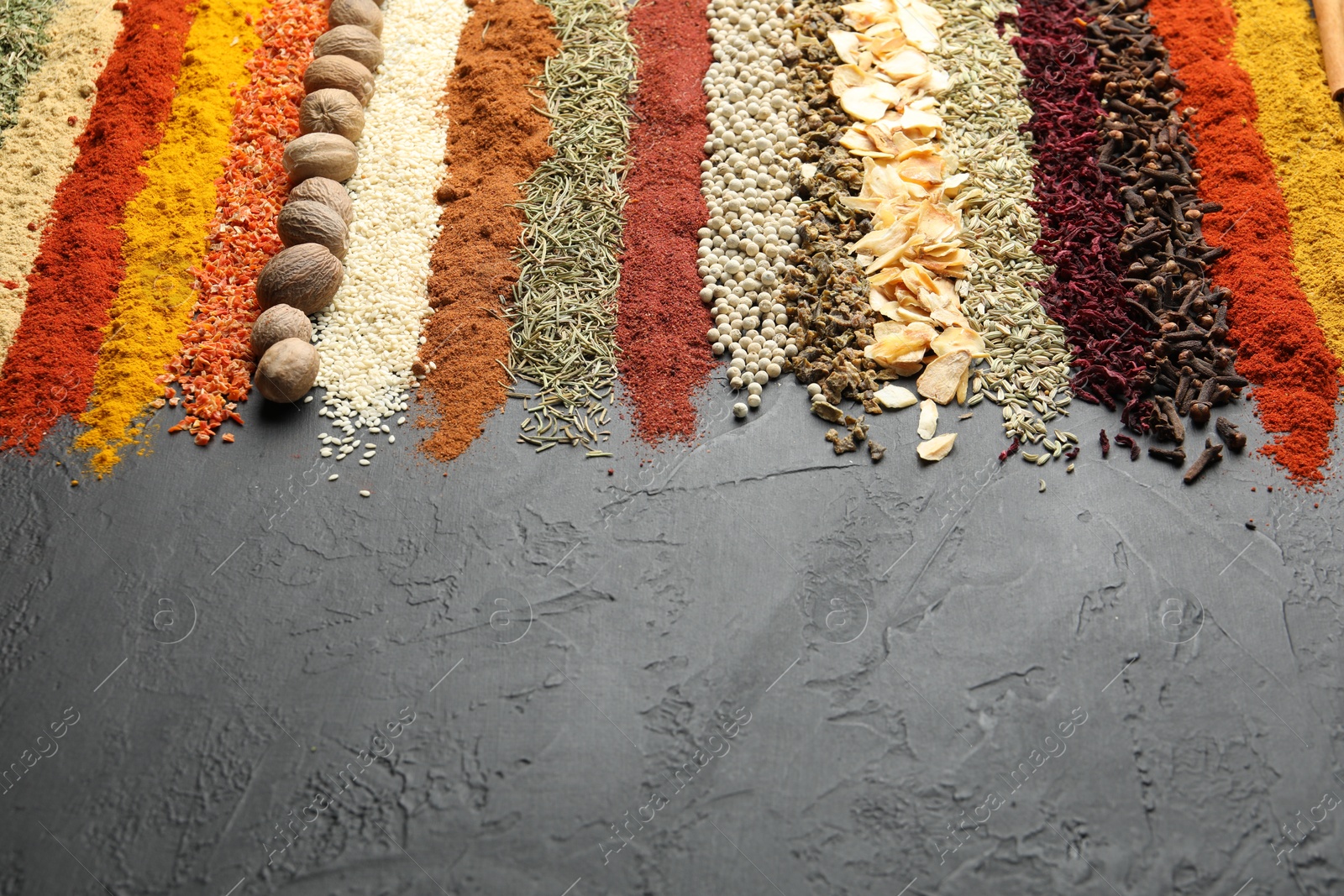 Many different spices on black table, closeup. Space for text Photo of Many different spices on black table, closeup. Space for text