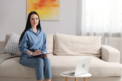 Photo of Professional psychologist with clipboard and pen in office
