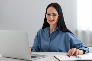 Photo of Professional psychologist working with laptop at table in office