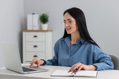 Photo of Professional psychologist working with laptop at table in office