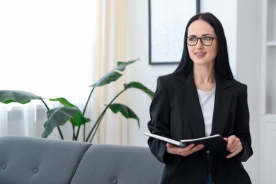 Photo of Professional psychologist with notebook in office, space for text