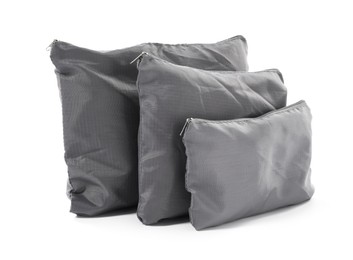 Photo of Grey packing bags isolated on white. Storage organizer