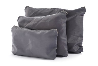 Photo of Grey packing bags isolated on white. Storage organizer