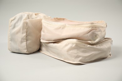 Photo of Packing cubes with clothes on light grey background