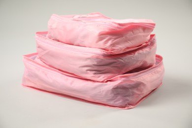 Photo of Packing cubes with clothes on light grey background