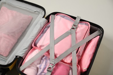 Photo of Open suitcase with packing cubes on light grey background, above view