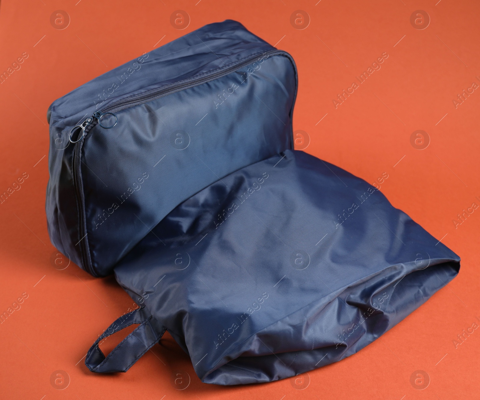 Packing cubes with clothes on bright orange background, closeup Photo of Packing cubes with clothes on bright orange background, closeup