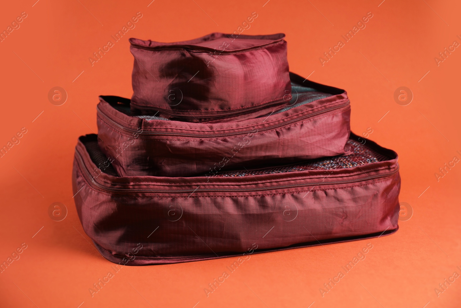 Packing cubes with clothes on bright orange background Photo of Packing cubes with clothes on bright orange background