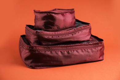 Photo of Packing cubes with clothes on bright orange background