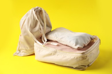 Photo of Packing cubes with clothes on yellow background