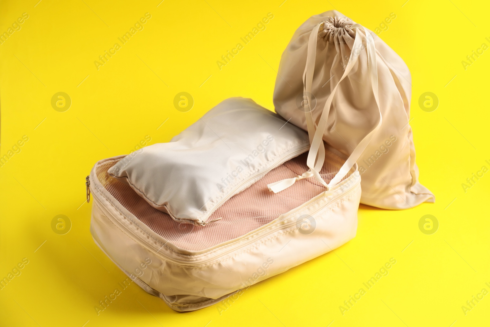 Packing cubes with clothes on yellow background Photo of Packing cubes with clothes on yellow background