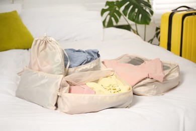 Photo of Packing cubes with clothes on bed indoors