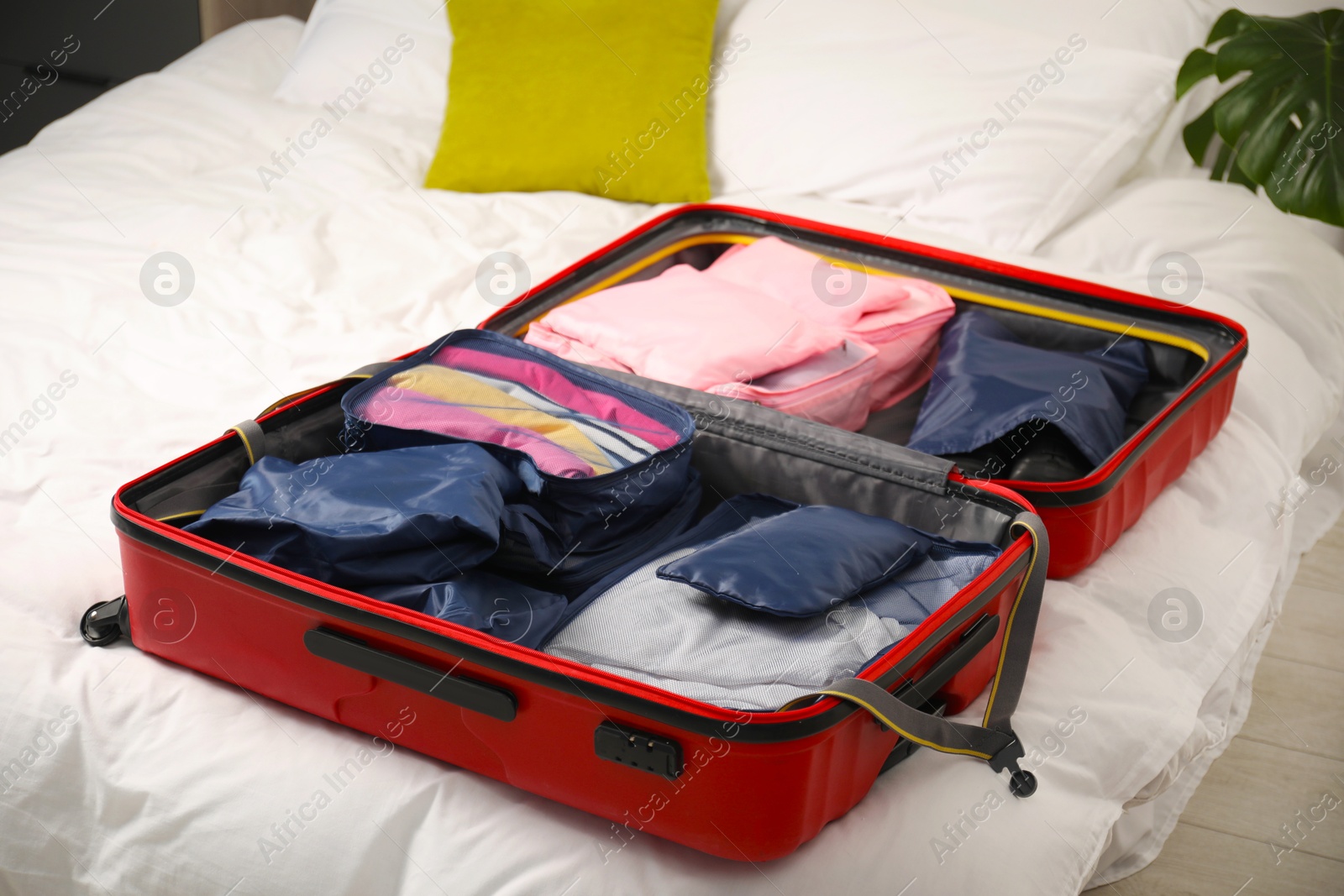 Open suitcase with packing cubes on bed indoors, closeup Photo of Open suitcase with packing cubes on bed indoors, closeup