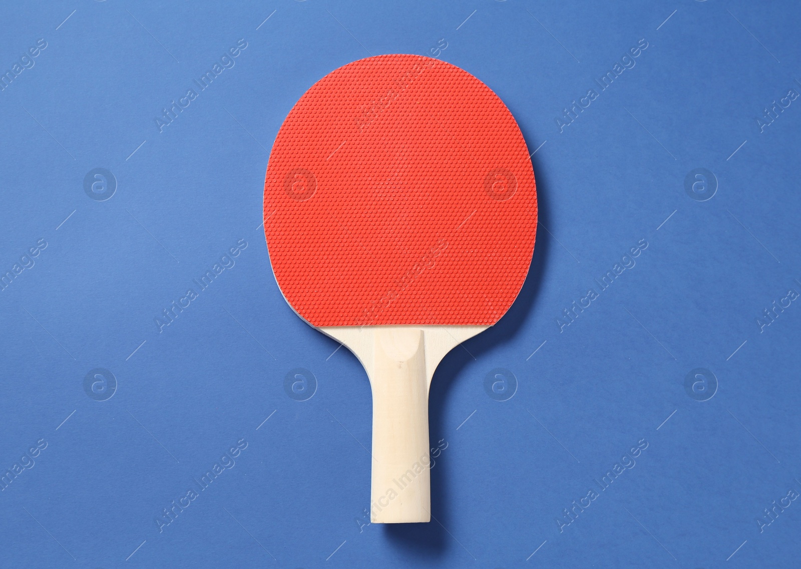 One ping pong racket on blue background, top view Photo of One ping pong racket on blue background, top view
