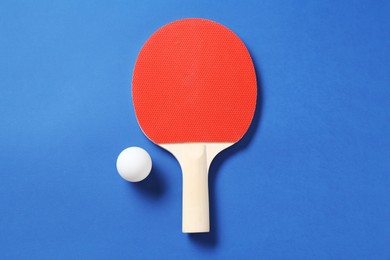 Photo of Ping pong racket and ball on blue background, top view