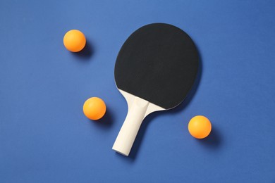 Photo of Ping pong racket and balls on blue background, top view