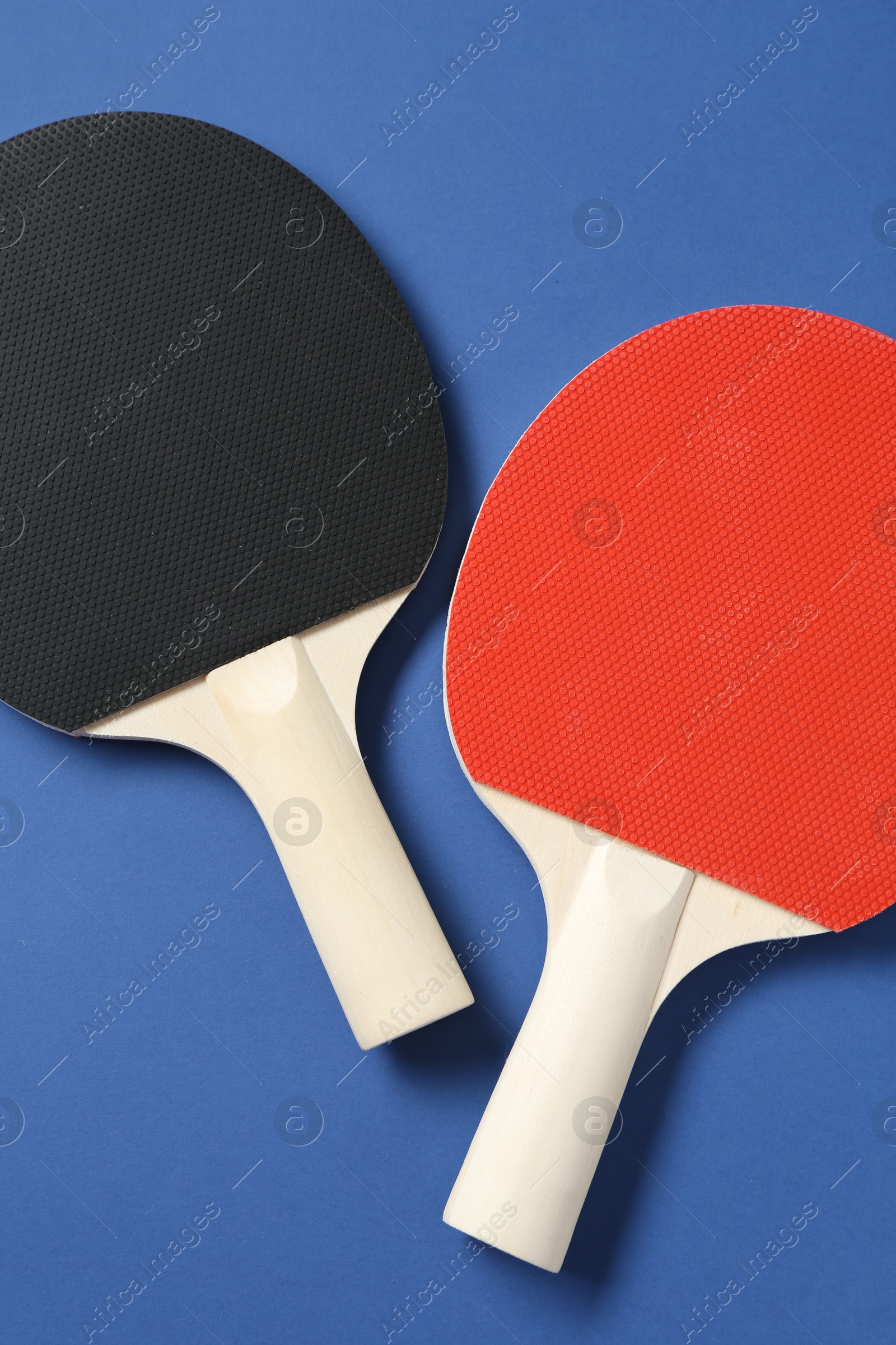 Ping pong rackets on blue background, top view Photo of Ping pong rackets on blue background, top view