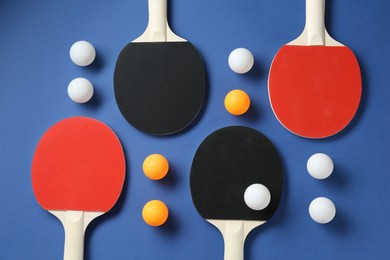 Photo of Ping pong rackets and balls on blue background, flat lay