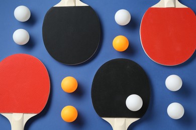Photo of Ping pong rackets and balls on blue background, flat lay