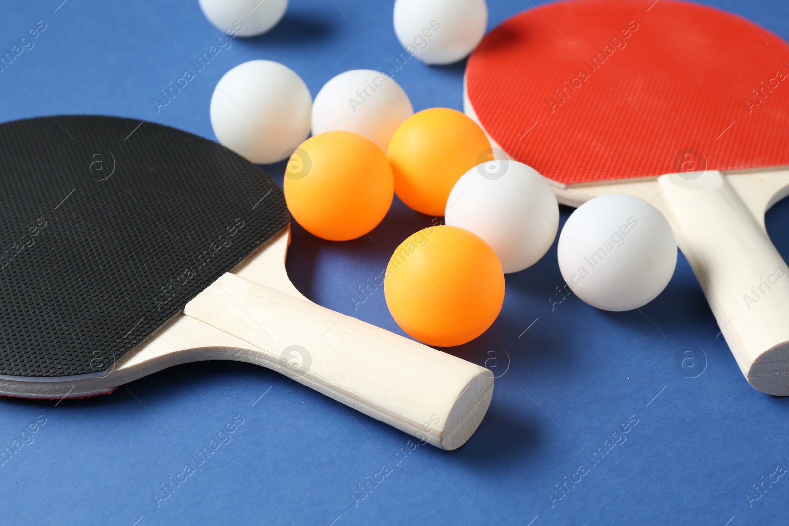 Ping pong rackets and balls on blue background, closeup Photo of Ping pong rackets and balls on blue background, closeup