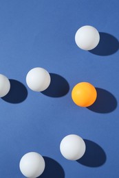 Photo of Many ping pong balls on blue background, flat lay