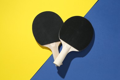 Photo of Ping pong rackets on color background, top view