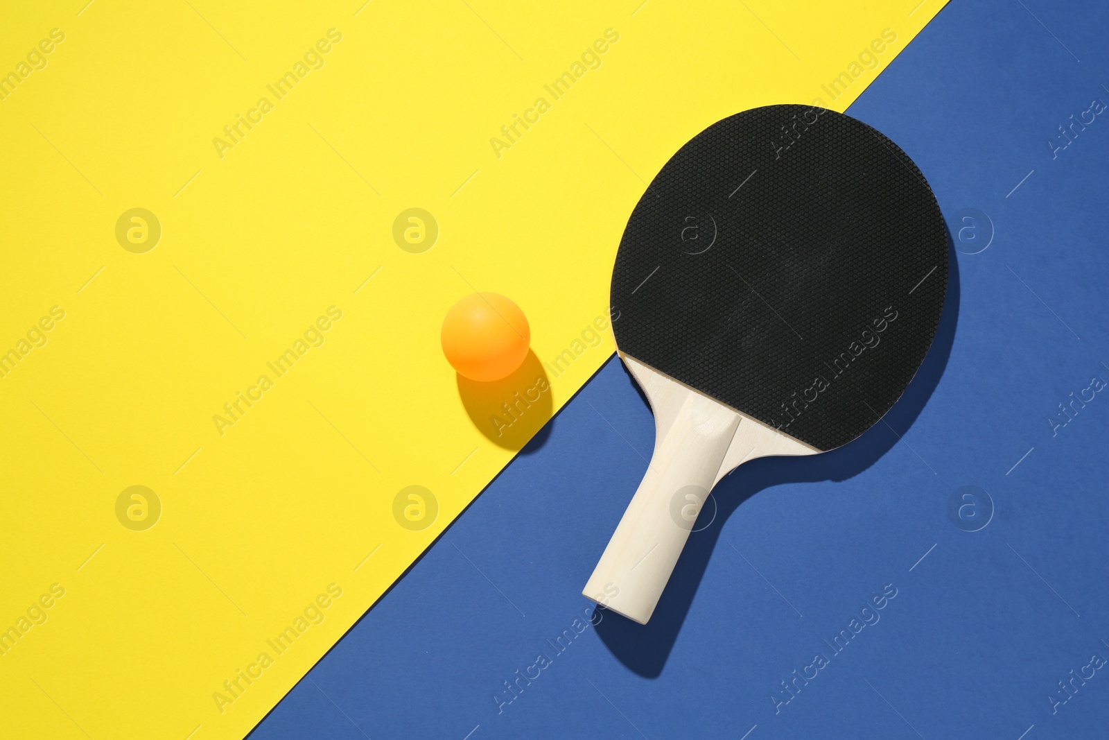 Ping pong racket and ball on color background, top view. Space for text Photo of Ping pong racket and ball on color background, top view. Space for text