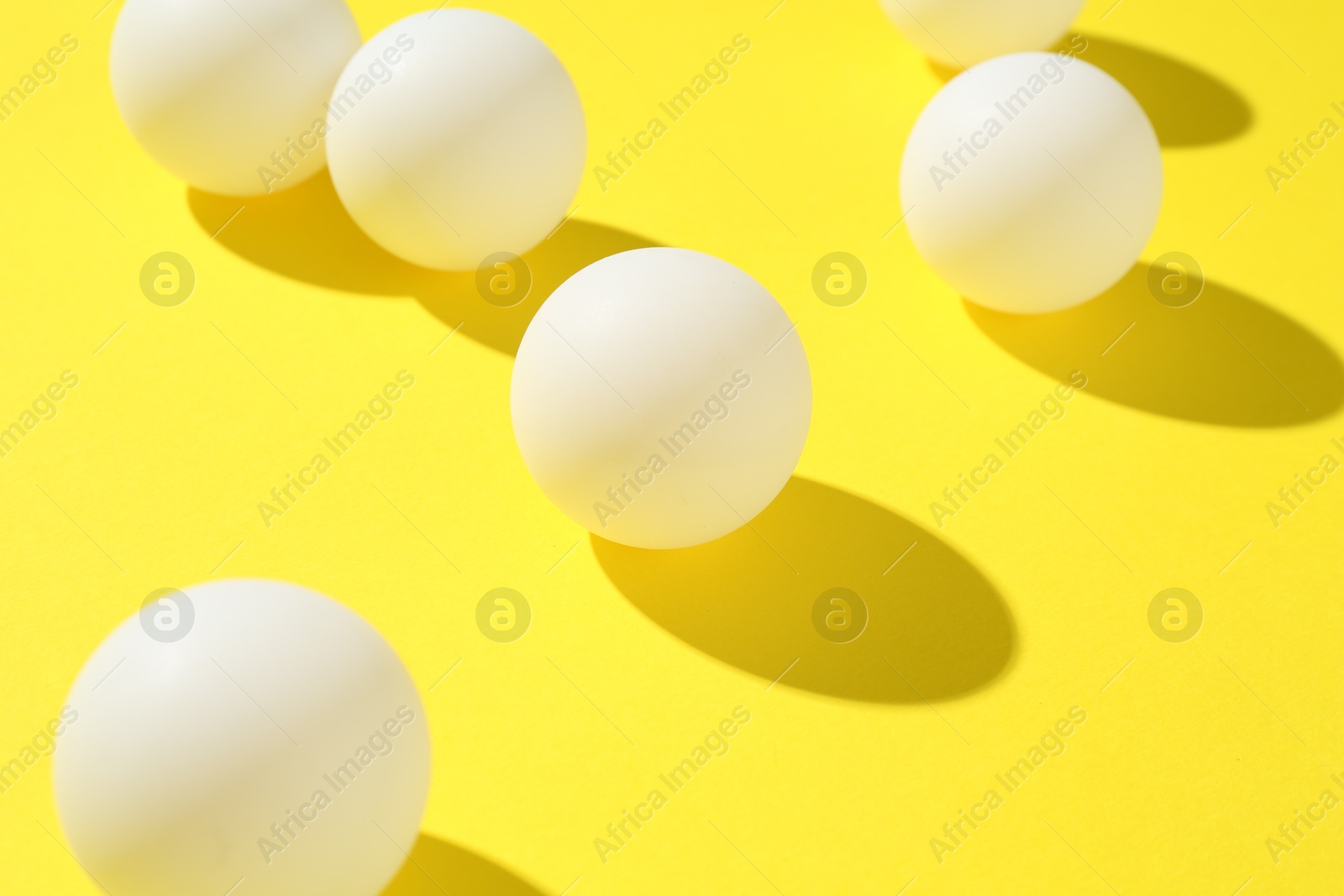 Ping pong balls on yellow background, closeup Photo of Ping pong balls on yellow background, closeup