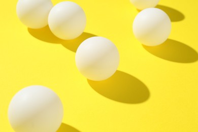 Photo of Ping pong balls on yellow background, closeup