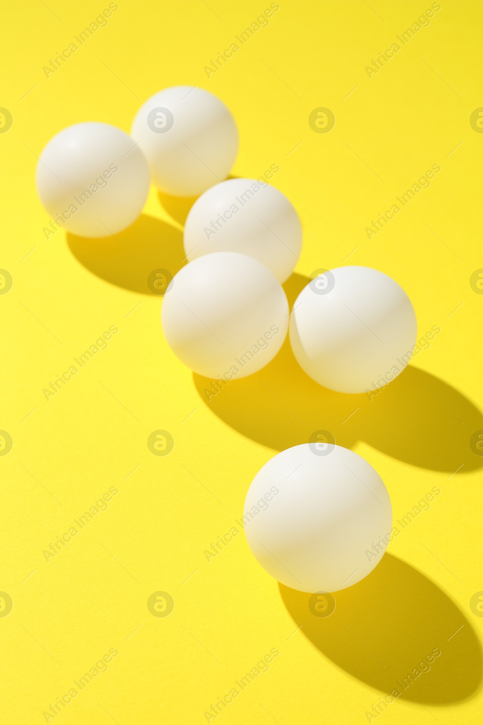 Ping pong balls on yellow background, closeup Photo of Ping pong balls on yellow background, closeup