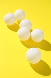 Photo of Ping pong balls on yellow background, closeup