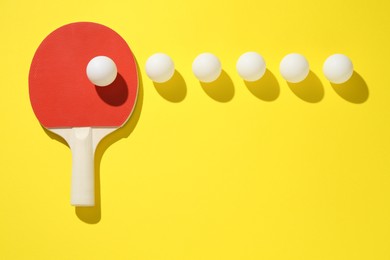 Photo of Ping pong racket and balls on yellow background, flat lay