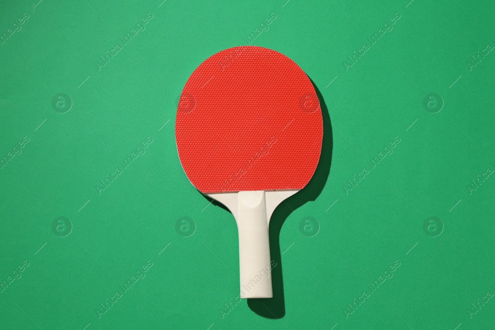 One ping pong racket on green background, top view Photo of One ping pong racket on green background, top view